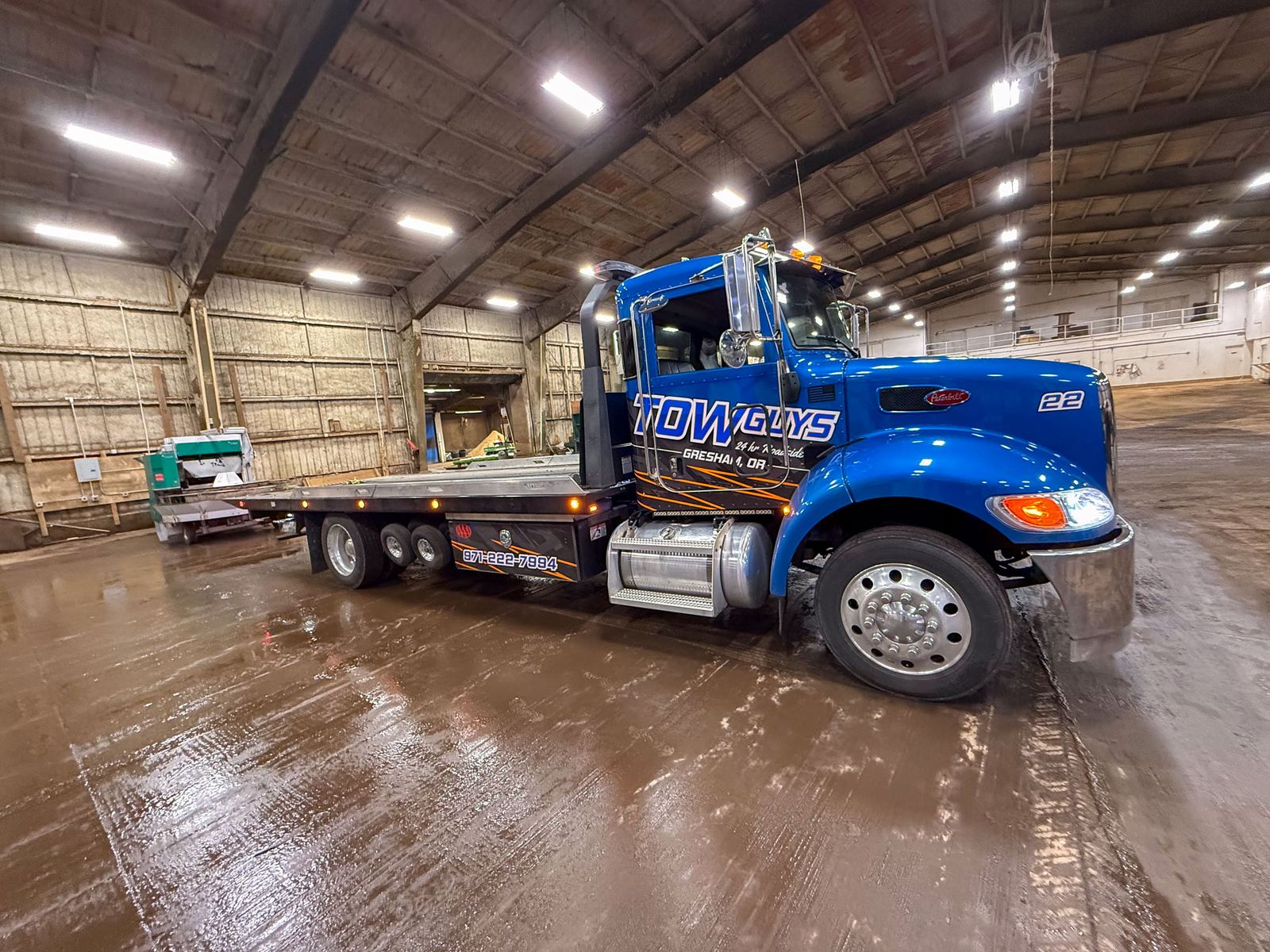 Tow Guys flatbed tow truck inside a warehouse