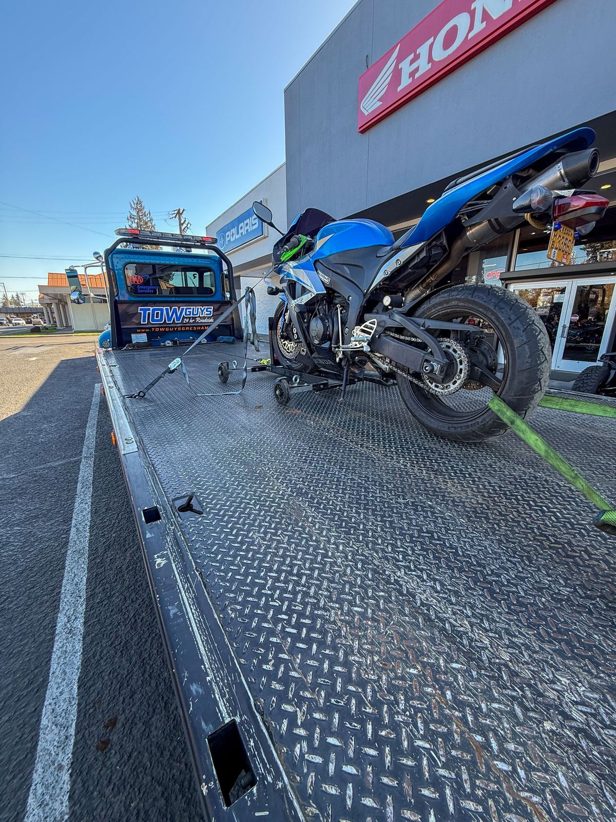 Motorcycle strapped to a Tow Guys flatbed at a Honda dealer