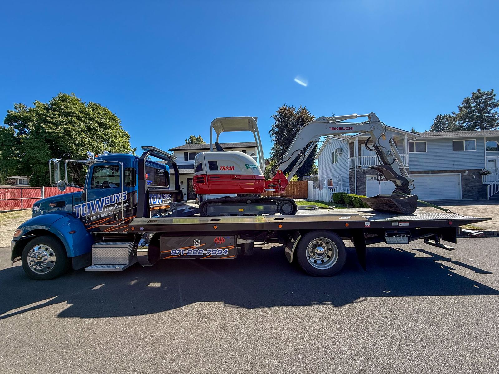 Mini excavator hauled on a Tow Guys flatbed in a Gresham neighborhood